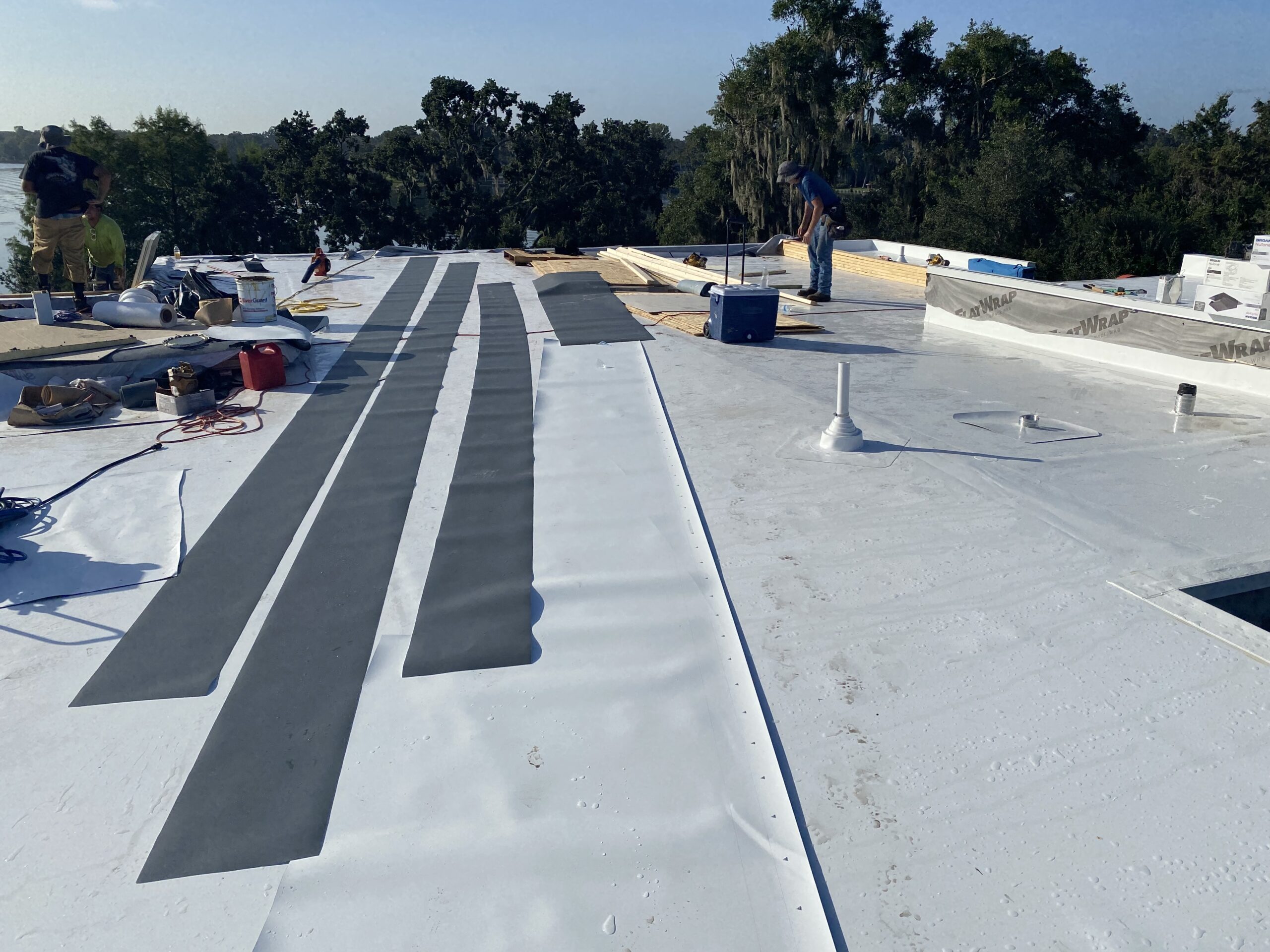 Roofing crew working on a commercial flat roof